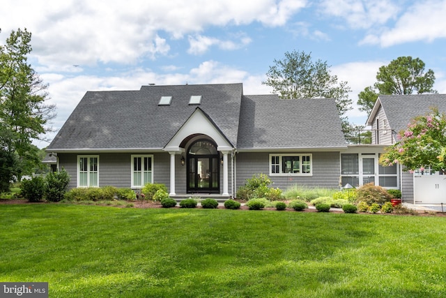 view of front of home featuring a shingled roof and a front yard