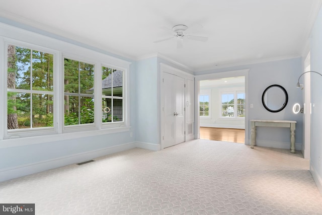 unfurnished living room with ornamental molding, a ceiling fan, visible vents, and baseboards