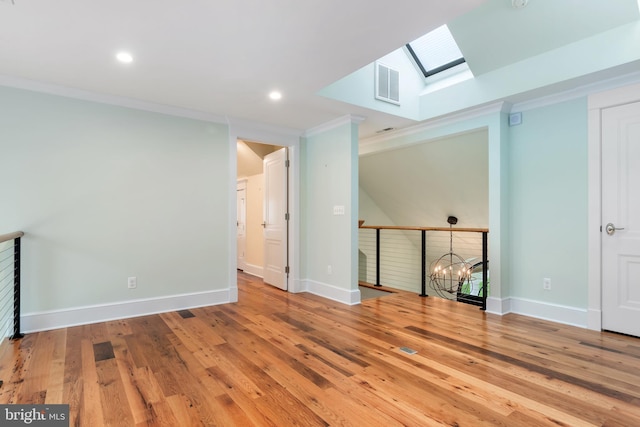 unfurnished room featuring baseboards, wood-type flooring, visible vents, and crown molding