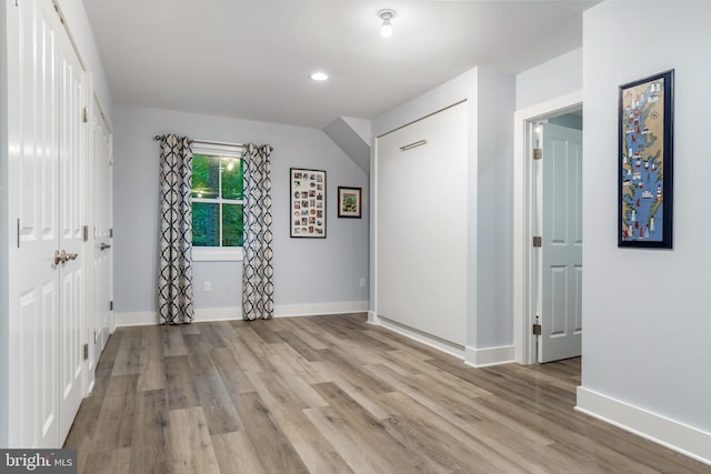 unfurnished room with light wood-type flooring and baseboards