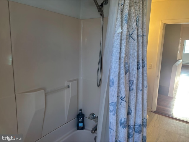 bathroom featuring hardwood / wood-style flooring and shower / bath combo with shower curtain