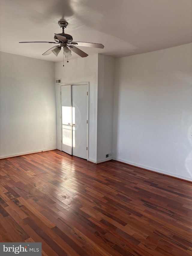 spare room with dark hardwood / wood-style flooring and ceiling fan