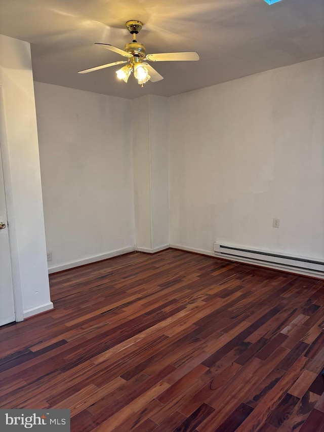 spare room featuring dark hardwood / wood-style floors, baseboard heating, and ceiling fan