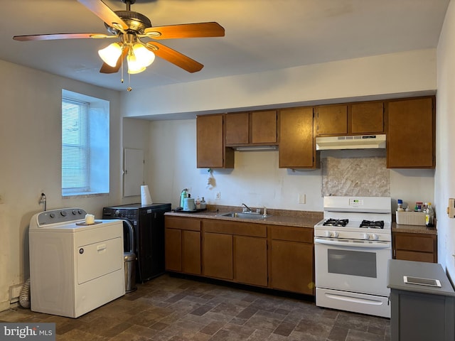 kitchen featuring backsplash, sink, ceiling fan, separate washer and dryer, and white gas stove