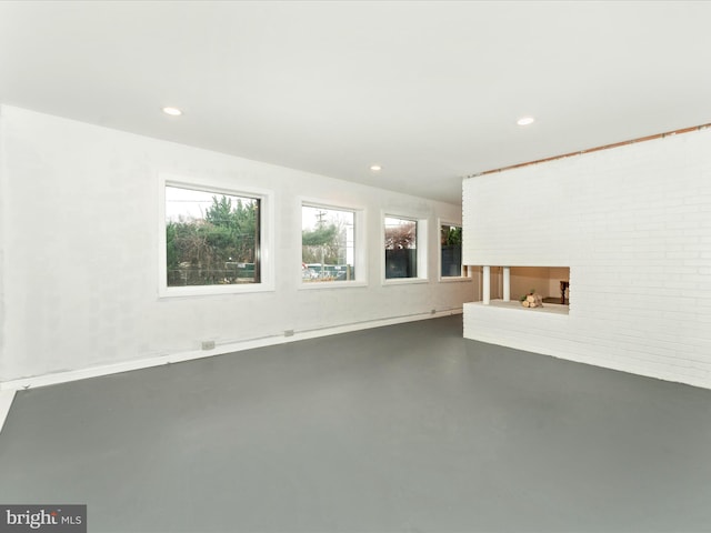 unfurnished living room with a fireplace and concrete floors