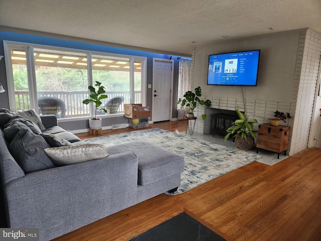 living room with a fireplace, wood-type flooring, and a wealth of natural light