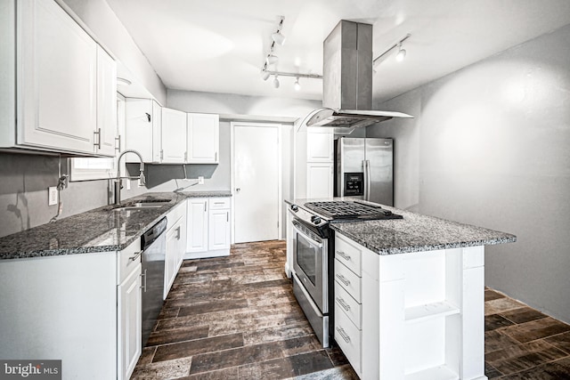 kitchen featuring dark wood-type flooring, stainless steel appliances, dark stone counters, island range hood, and white cabinets