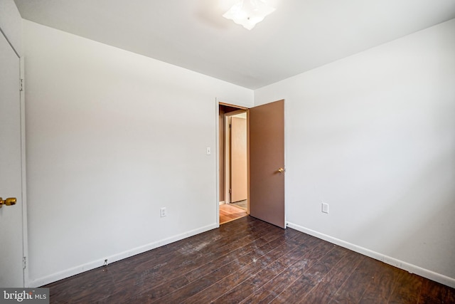 empty room with dark hardwood / wood-style floors