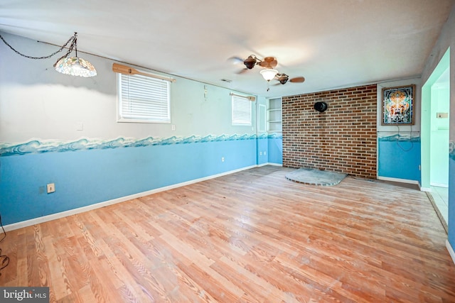 spare room with hardwood / wood-style floors and brick wall