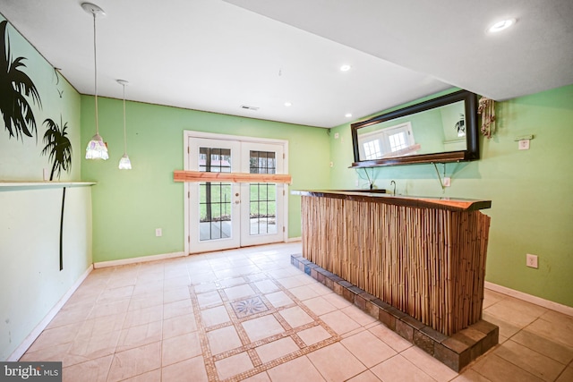 bar featuring french doors, decorative light fixtures, and light tile patterned floors