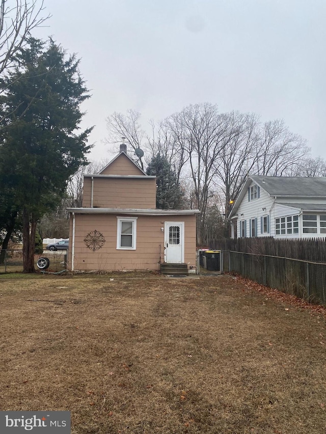 rear view of property featuring a lawn