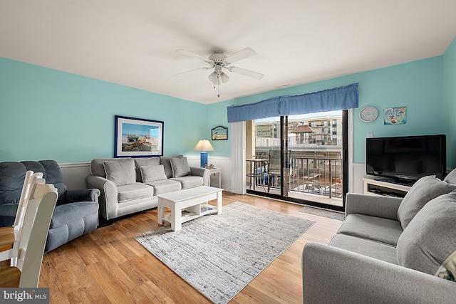 living room with light hardwood / wood-style floors and ceiling fan