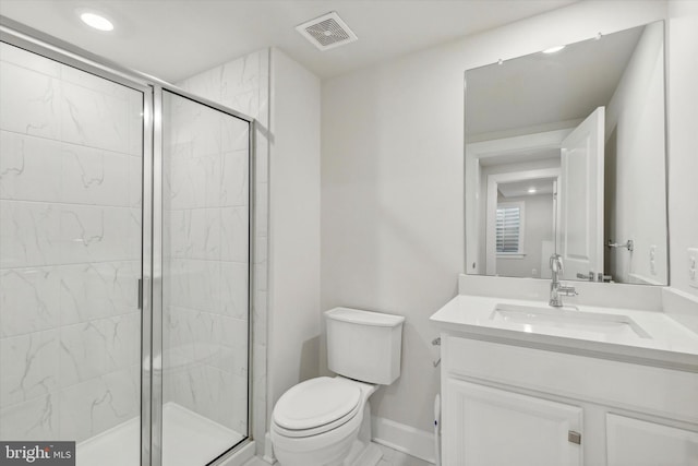 bathroom with vanity, a shower with shower door, and toilet