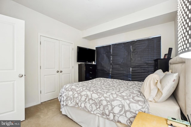 bedroom with light carpet and a closet