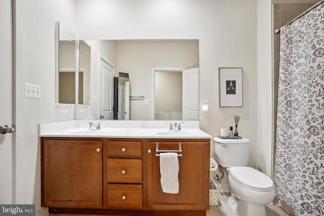 bathroom featuring curtained shower, vanity, and toilet