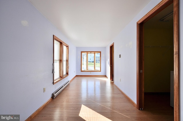 hallway featuring light hardwood / wood-style flooring and a baseboard heating unit