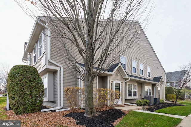 view of front of home with a front lawn and central air condition unit