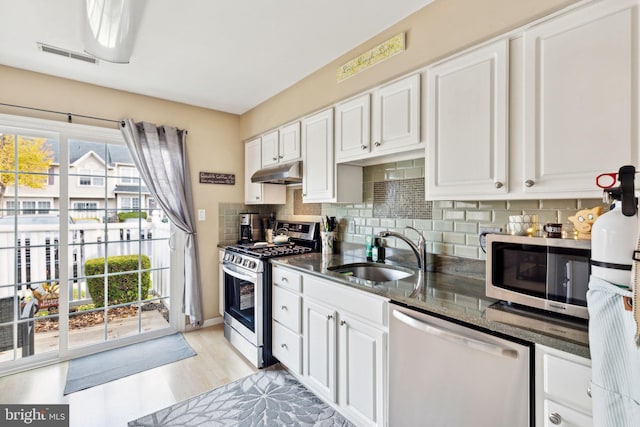 kitchen featuring appliances with stainless steel finishes, light wood-type flooring, white cabinetry, and sink