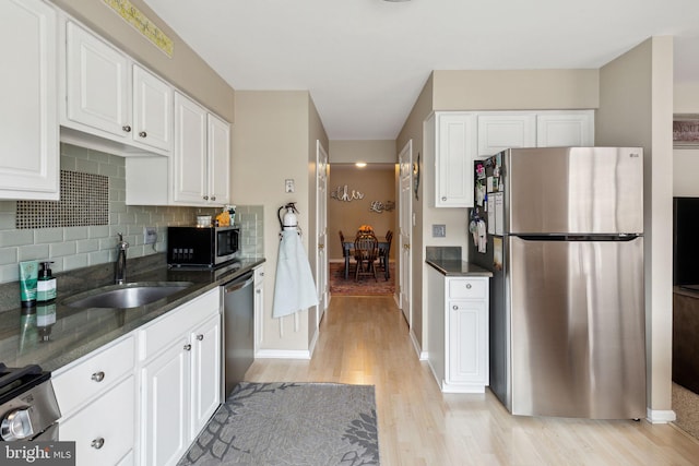 kitchen with white cabinetry, sink, stainless steel appliances, and light wood-type flooring