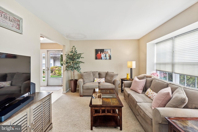 living room with plenty of natural light and light colored carpet