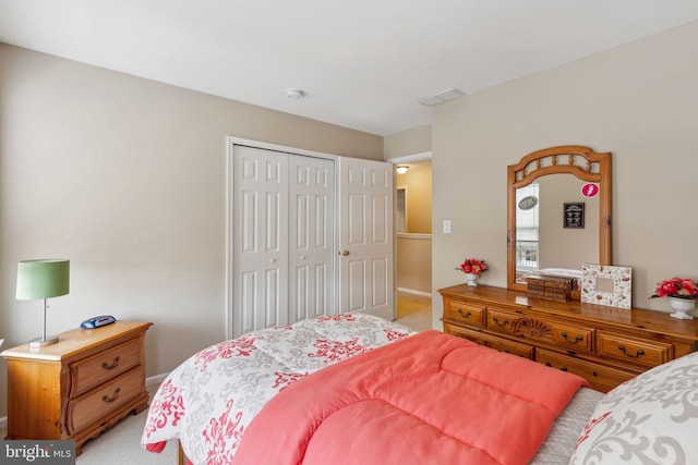 bedroom with light carpet and a closet