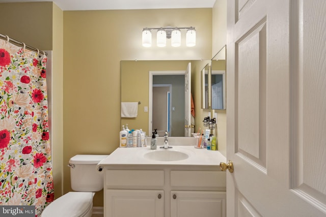 bathroom featuring a shower with curtain, vanity, and toilet