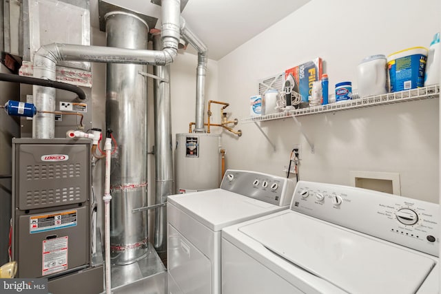 clothes washing area with water heater and washer and clothes dryer