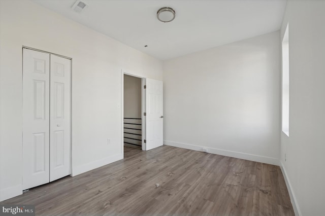 unfurnished bedroom with light hardwood / wood-style floors and a closet