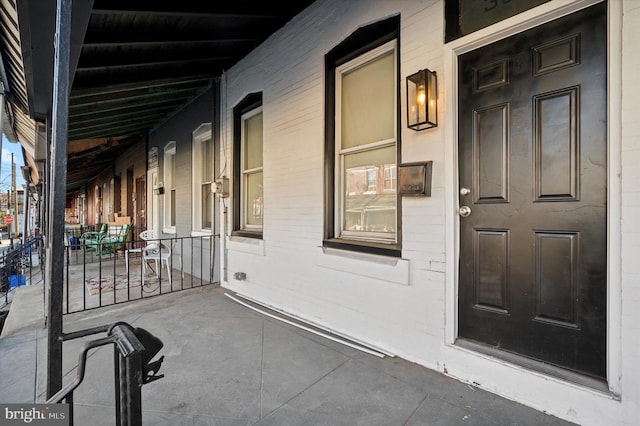 view of exterior entry featuring covered porch