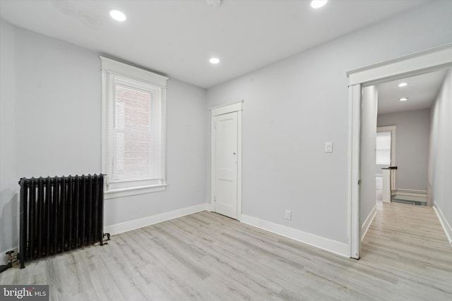 spare room with light wood-type flooring and radiator heating unit