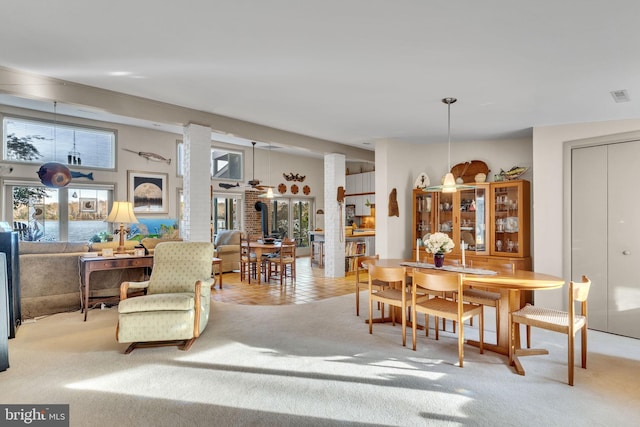 dining area featuring ornate columns and light carpet