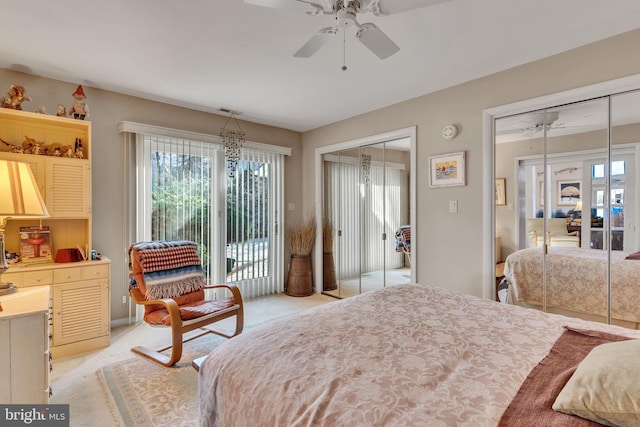 bedroom with two closets, light colored carpet, and ceiling fan