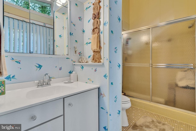 bathroom featuring tile patterned floors, vanity, toilet, and walk in shower