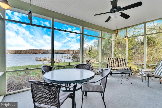 sunroom featuring ceiling fan and a water view