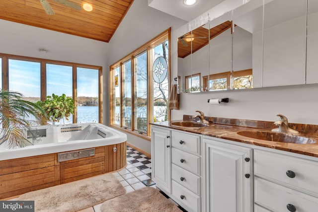 bathroom featuring lofted ceiling, a water view, ceiling fan, and a healthy amount of sunlight