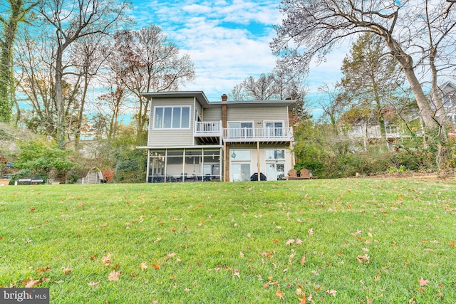 back of property featuring a sunroom, a yard, a deck, and a storage unit