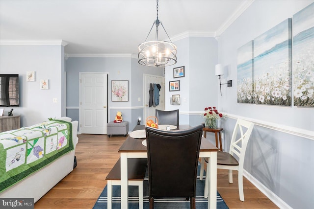 dining area with a notable chandelier, hardwood / wood-style flooring, and ornamental molding