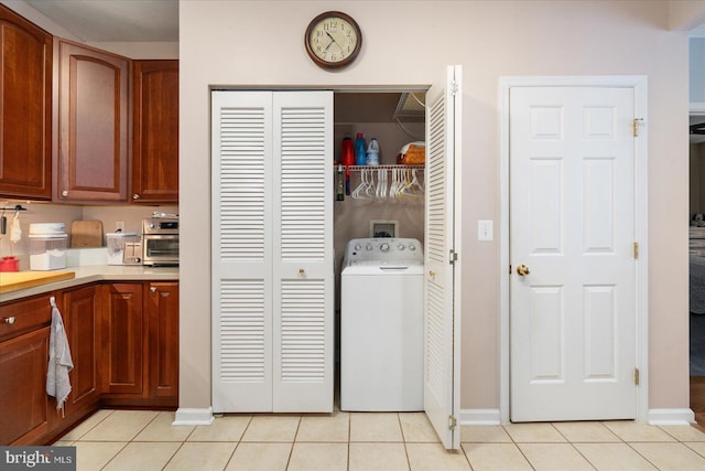 laundry area with washer / dryer and light tile patterned floors