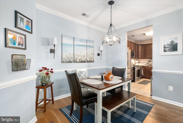 dining area featuring ornamental molding and light wood-type flooring