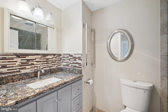 bathroom with decorative backsplash, vanity, and toilet