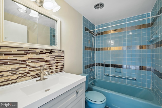 full bathroom featuring tasteful backsplash, toilet, vanity, and tiled shower / bath