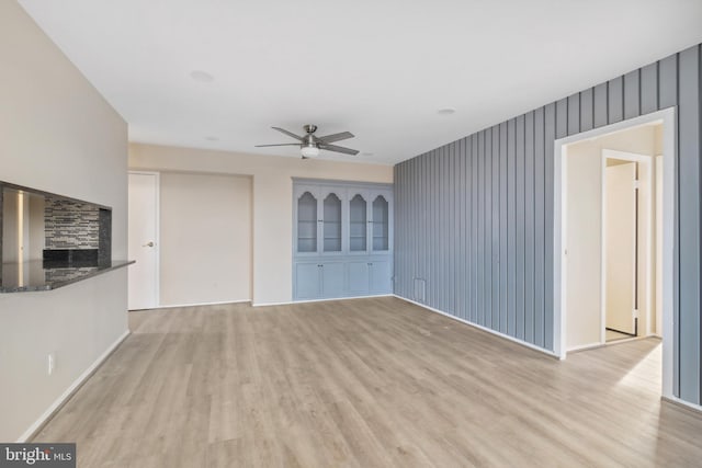 unfurnished living room featuring ceiling fan and light wood-type flooring