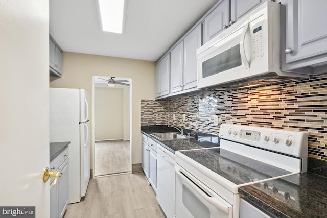 kitchen with white appliances, sink, decorative backsplash, gray cabinets, and light hardwood / wood-style floors