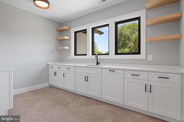 bar with a sink, visible vents, and baseboards