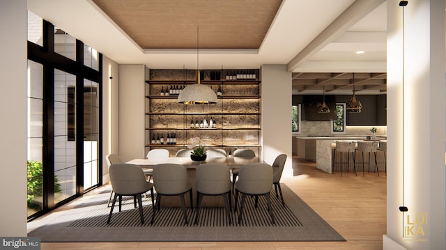 dining room with hardwood / wood-style flooring, a raised ceiling, and indoor bar