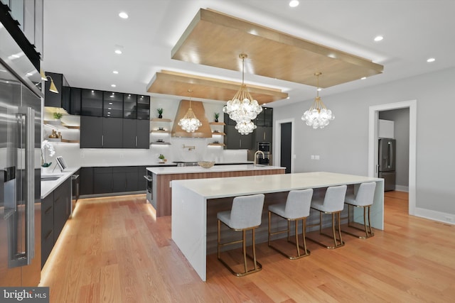 kitchen with a breakfast bar area, a spacious island, open shelves, stainless steel refrigerator with ice dispenser, and modern cabinets