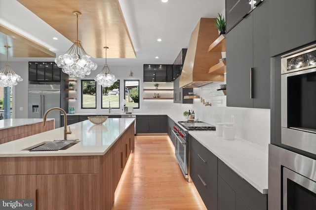 kitchen featuring modern cabinets, open shelves, wall chimney range hood, decorative backsplash, and built in appliances