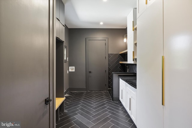 kitchen featuring white cabinetry, tile walls, and dark countertops