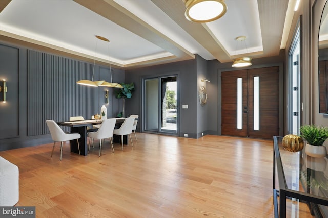 entryway featuring a tray ceiling, light wood-style flooring, and french doors