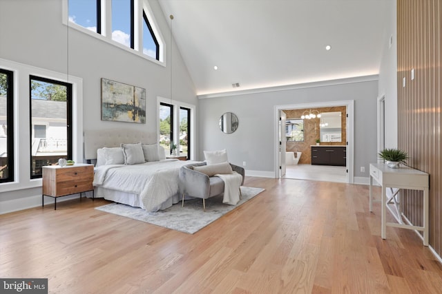 bedroom with ensuite bath, light hardwood / wood-style flooring, high vaulted ceiling, and a notable chandelier